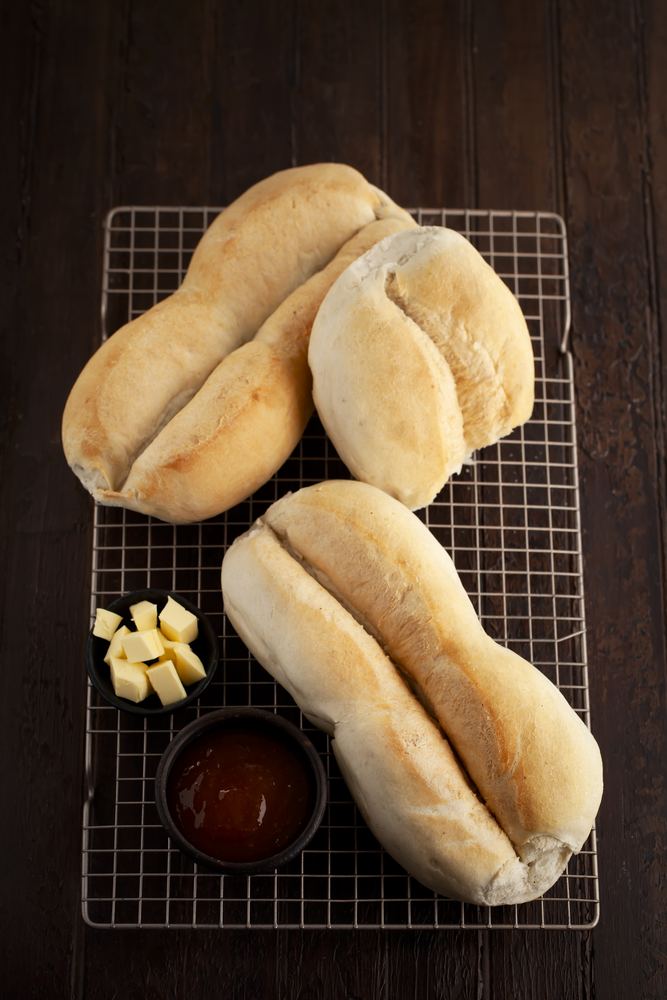 Marraquetas sobre una rejilla con mantequilla y pebre